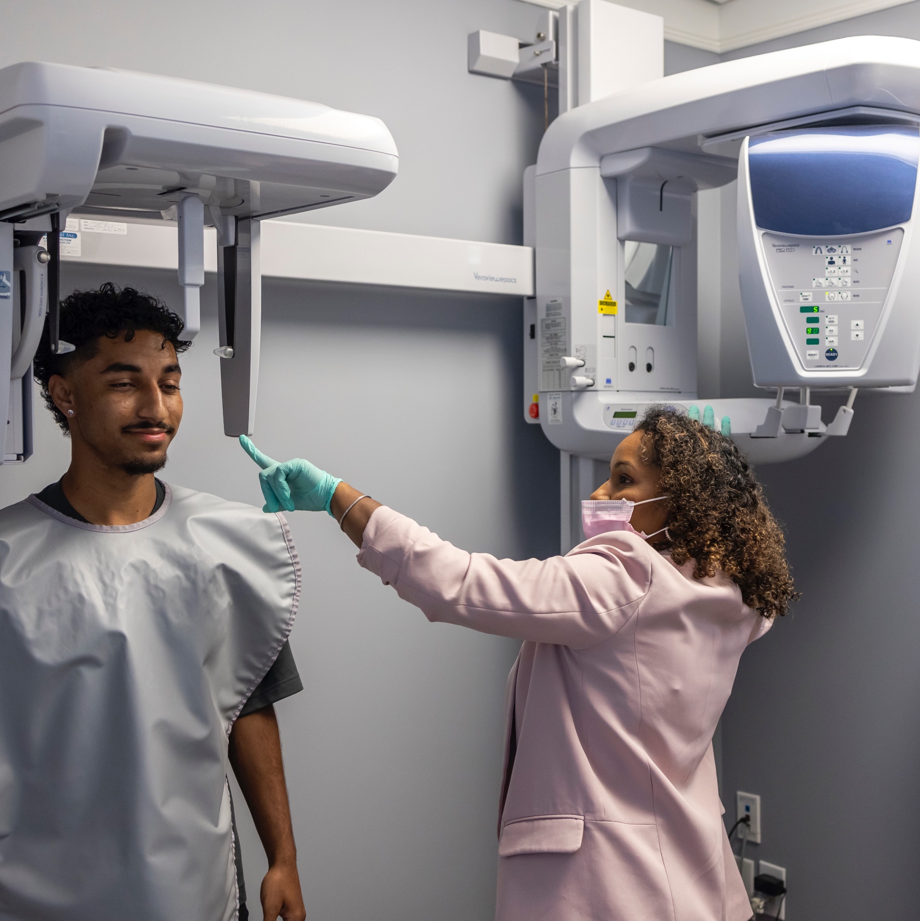 Debbie positioning a patient for a panoramic scan at Discover Orthodontics
