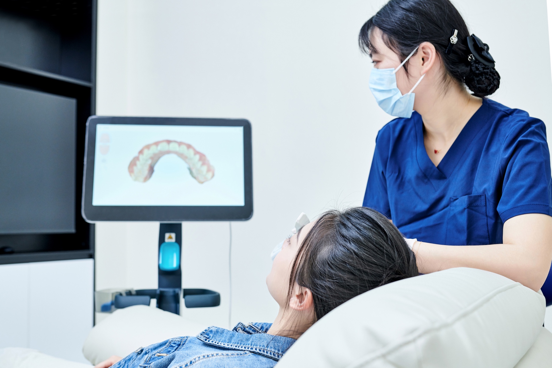 A clinician reviewing a digital intraoral scan on a chairside monitor with a patient