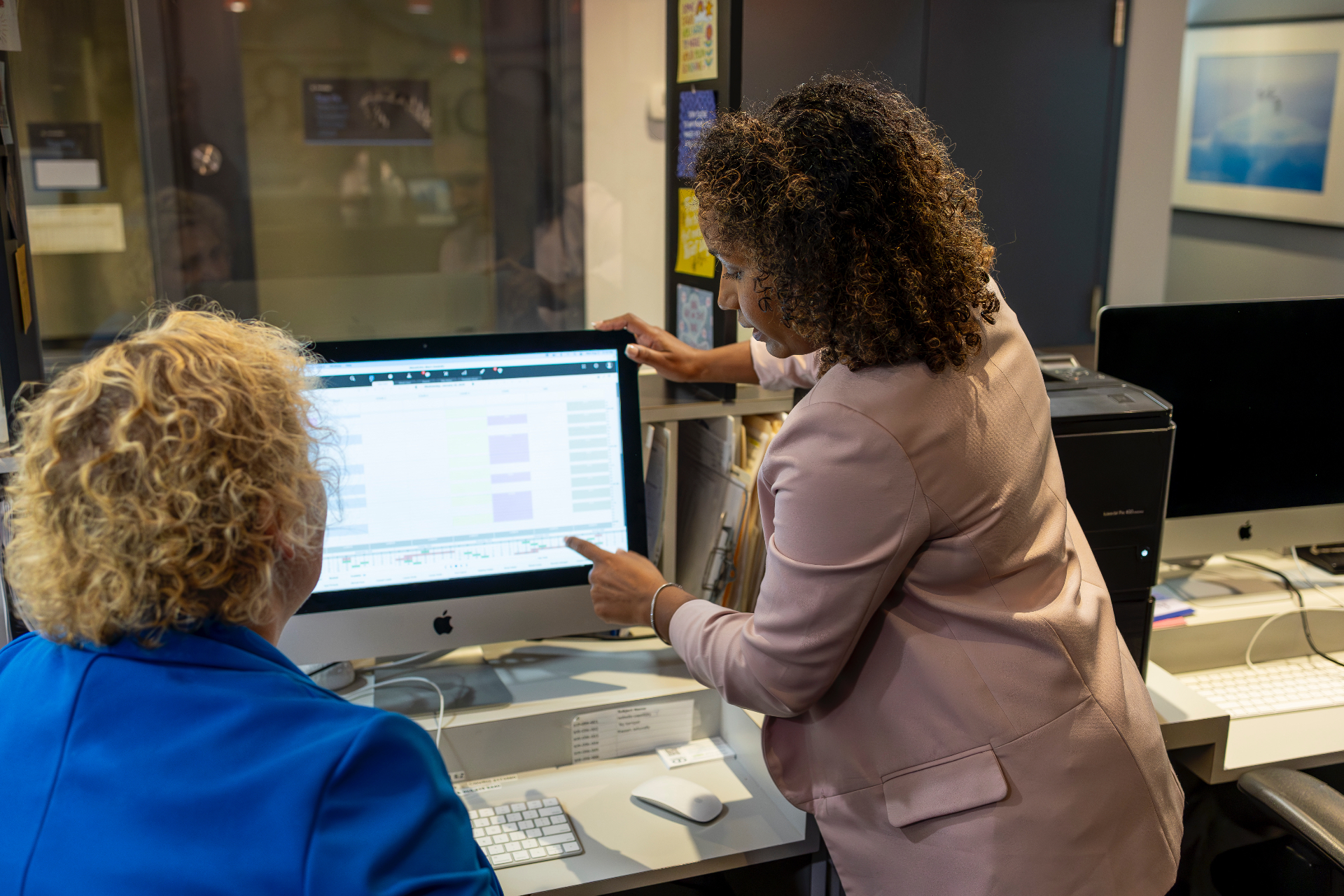 Debbie Khedoo reviewing operational workflows on a monitor with a team member inside a practice